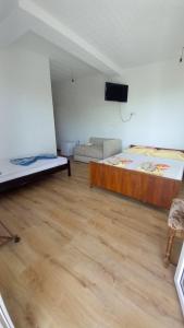 a room with a bed and a couch and a television at Villa Bardha in Struga