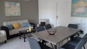ein Wohnzimmer mit einem Tisch, Stühlen und einem Sofa in der Unterkunft Apartment Delfina in Ist