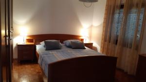 um quarto com uma cama com duas almofadas em Apartment Delfina em Ist