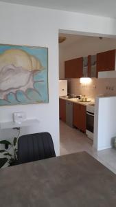 a kitchen with a table and a painting on the wall at Apartment Delfina in Ist