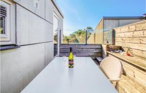 a bottle of wine sitting on a table on a balcony at Gorgeous Apartment In Schiermonnikoog in Schiermonnikoog +14 photos