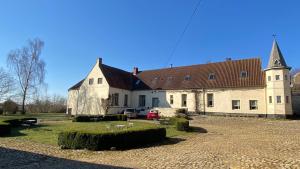 a large white building with a clock tower on it at La Ferme Saint Pierre de Glabais in Genappe