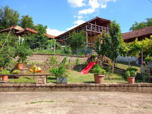 a house with a playground with a red slide at House Seoska OAZA in Crnoklište