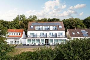 Un grand bâtiment blanc avec balcon est disponible. dans l'établissement Hotel Südblick, à Norderney