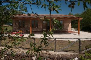 ein kleines Haus mit einem Zaun davor in der Unterkunft Agriturismo Don Lucifero in Orosei