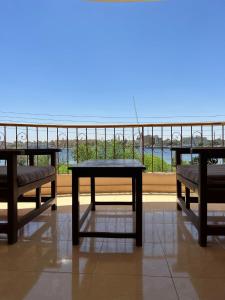 d'une table et de bancs sur un balcon avec vue. dans l'établissement Luxor Plaza House, à Louxor