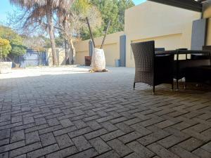 un patio avec une table et des chaises dans un bâtiment dans l'établissement Ikhutse Manor Guesthouse, à Mahikeng