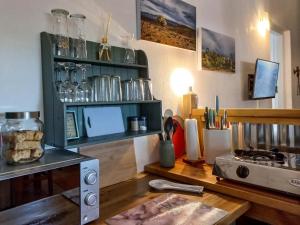 a kitchen with a counter with a stove and a shelf with glasses at 18 on Mark in Willowmore