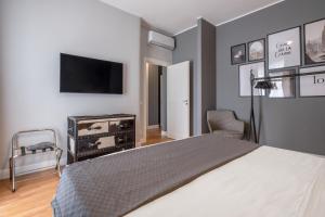 een slaapkamer met een bed en een tv aan de muur bij SWEET LIFE - LUXURY APARTMENT-SUITE-ROOMS in Bari