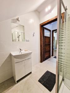 a white bathroom with a sink and a mirror at GraVelo - Noclegi in Bartkowa-Posadowa