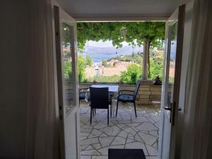 a door leading to a patio with a table and chairs at Apartments Lumbarda in Lumbarda