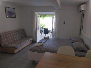 a living room with a bed and a couch at Apartments Lumbarda in Lumbarda