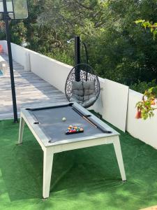 a ping pong table sitting on a lawn with a chair at une maison avec piscine chauffée in Mouguerre