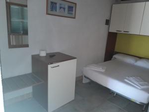 メタポントにあるCamping village Internazionaleのベッド1台と小さなキャビネット付きの小さな客室です。