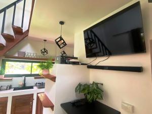 a living room with a large flat screen tv on a wall at S&S House in Srithanu