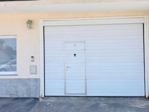 a white garage door with a small hole in it at Sunny app in Ljubljana