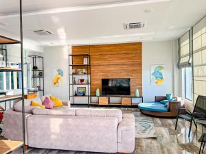 a living room with a couch and a tv at Chakvi Sunset in Chakvi