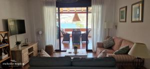 ein Wohnzimmer mit einem Sofa und Blick auf einen Innenhof in der Unterkunft Los Cipreses - Casa Ola in Almuñécar
