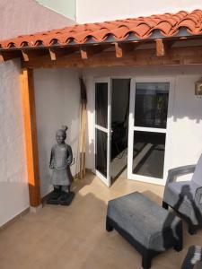 una estatua de un hombre sentado en un porche junto a una casa en Casa del Sol, en Mogán