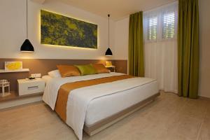 a bedroom with a large bed with green curtains at Holiday Homes Oliva in Bol +74 photos
