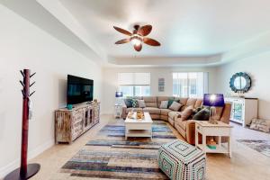 sala de estar con sofá y ventilador de techo en Coastal Serenity Retreat en Fort Myers