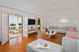 sala de estar con sofá y TV en Ionian Garden Villas - Villa Olea en Benitses