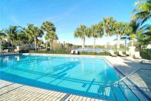 una gran piscina con sillas y palmeras en Coastal Serenity Retreat en Fort Myers