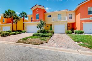 Casa grande de color naranja con puertas blancas de garaje en Coastal Serenity Retreat en Fort Myers