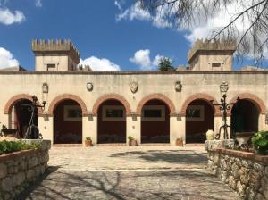 un edificio con archi e cortile in pietra di Casa vacanze nel cuore della sicilia a Santa Caterina Villarmosa