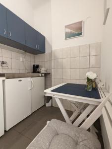 a small kitchen with a table and a refrigerator at Tilted Painting Near The Stone Gate in Zagreb