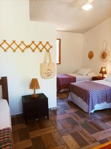 a room with two beds and a table with lamps at Pousada Luar do Sertão in Lençóis