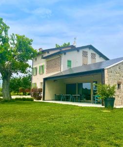 a house with a patio and a grass yard at Agriturismo Redó in Ponti Sul Mincio