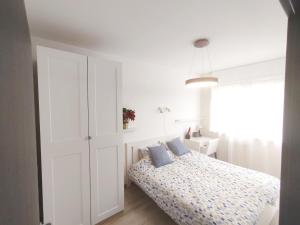 um quarto branco com uma cama com almofadas azuis em Forest Hill apartment em Budapeste