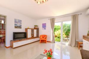 a living room with a television and a table at Apartman Mirjana 1 in Mali Lošinj