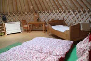 a room with two beds and a table in a yurt at Kirgisische Jurte der Hofmühle Pfaffroda in Olbernhau