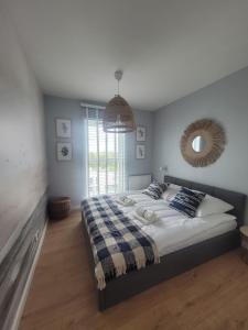 a bedroom with a large bed and a mirror at Baltika in Gdańsk