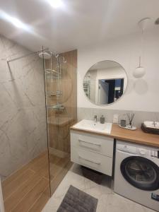 a bathroom with a shower and a washing machine at Baltika in Gdańsk +15 photos