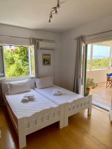 Un dormitorio con una gran cama blanca con gafas. en Elichrisos Apartment Spetses, en Spetses