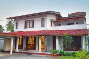 una grande casa bianca con tetto rosso di Luxury Colombo Escape a Talawatugoda