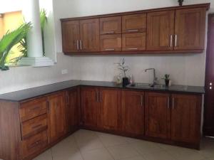 una cocina con armarios de madera y fregadero en Luxury Colombo Escape, en Talawatugoda