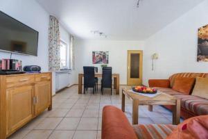 a living room with a couch and a table at Haus am Sonnenhang Typ B in Niedersalwey