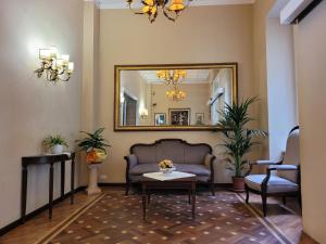 Hotel Villa Aricia في أريكتشيا: غرفة معيشة مع أريكة ومرآة