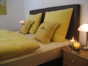 NiedersalweyにあるLandhaus Kraehenbergのベッド(黄色の枕、キャンドル2本付)
