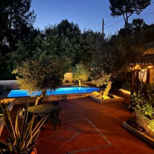 a backyard with a swimming pool at night at Villa Rios in Xàtiva