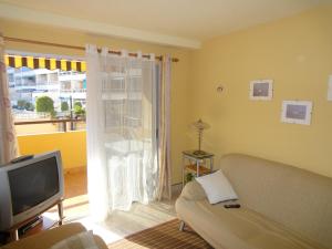 a living room with a couch and a television at Jardin Calpe Apartment in Calpe