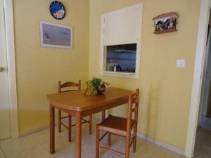 a dining room with a table and chairs and a window at Jardin Calpe Apartment in Calpe