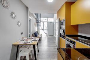 a kitchen with yellow and white cabinets and a table at Luminoso cerca 4 Caminos- Apartamento REINA VICTORIA in Madrid