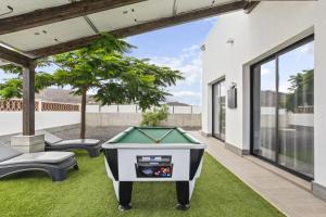 una mesa de billar en el patio trasero de una casa en Villas Mariposas Dreams, en Corralejo