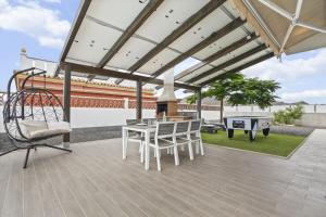 um pátio com uma mesa, cadeiras e comodidades para churrascos em Villas Mariposas Dreams em Corralejo