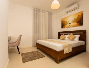 1 dormitorio con 1 cama, 1 mesa y 1 silla en Glowing Crescent en Rajagiriya